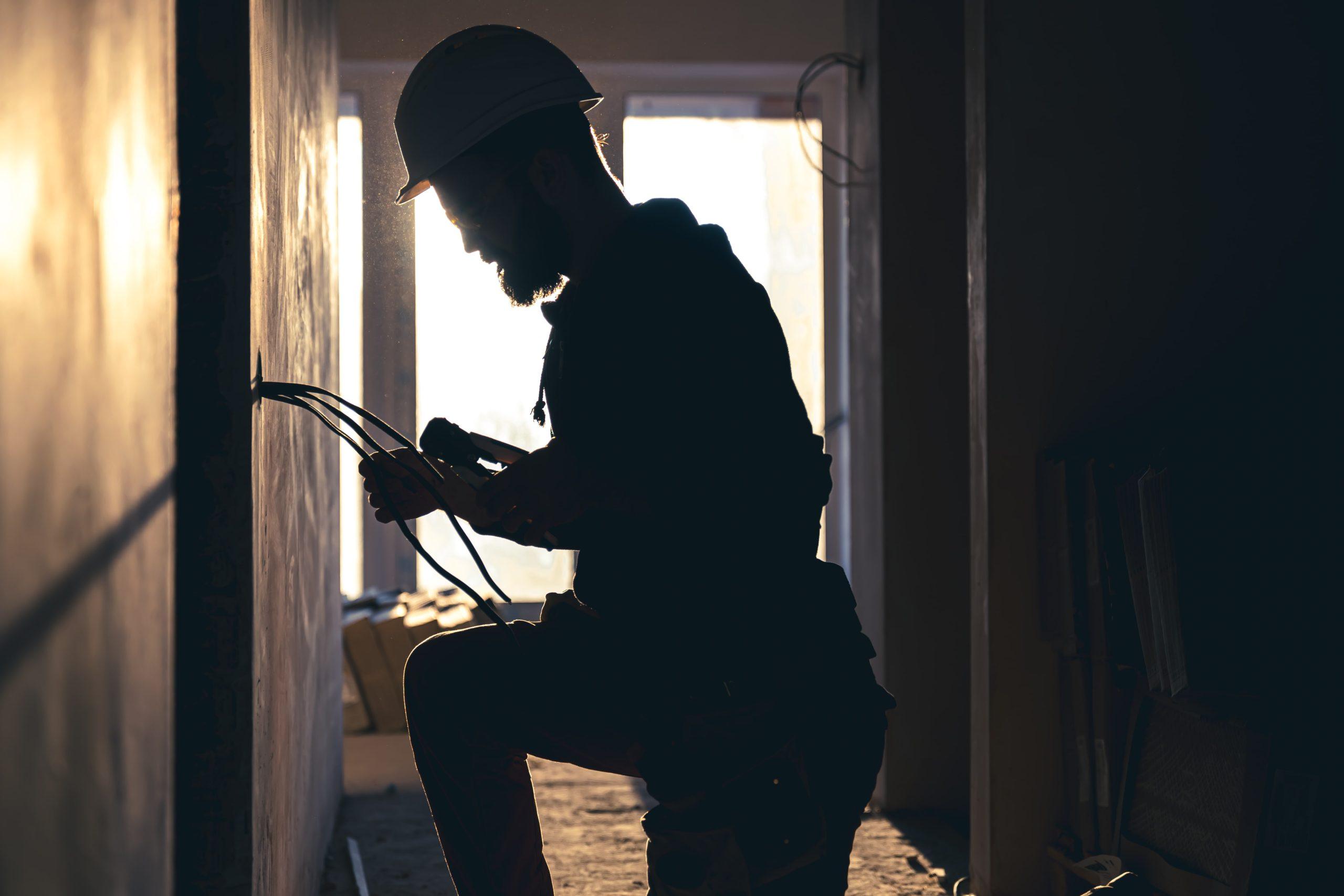 Licensed electrician inspecting a home battery storage system and switchboard